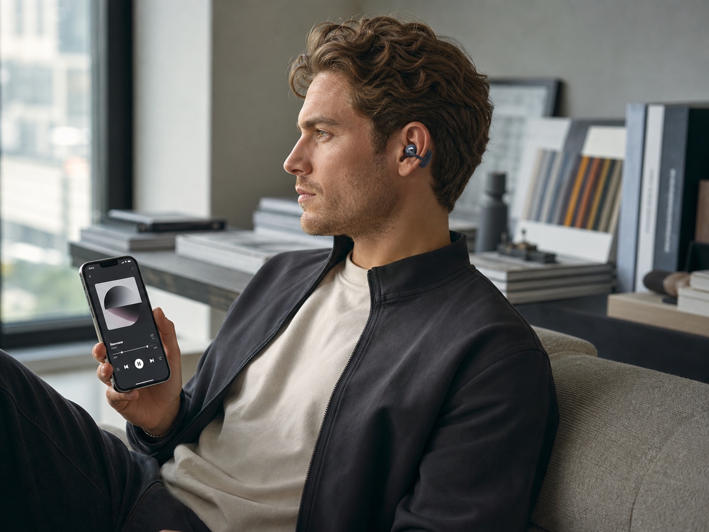 Stylish Western male professional wearing the vivolight clip-on earphone concept while listening to music from an iPhone.